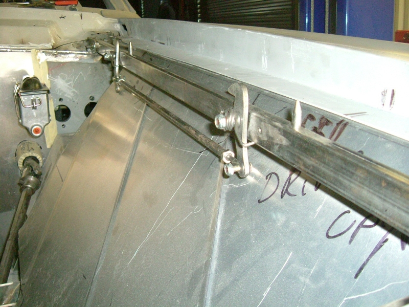 Hood latch system concealed beneath inner fender panel